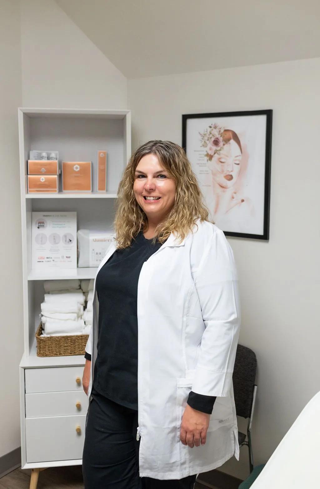 A woman in a white lab coat is standing in a room.
