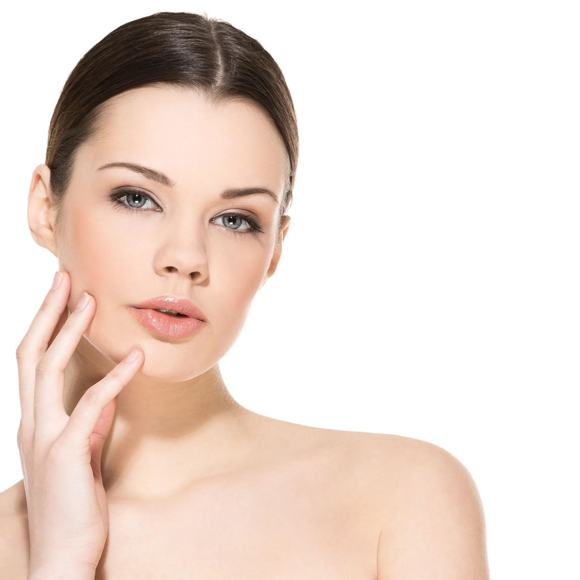 A woman touches her face with her hand while looking at the camera