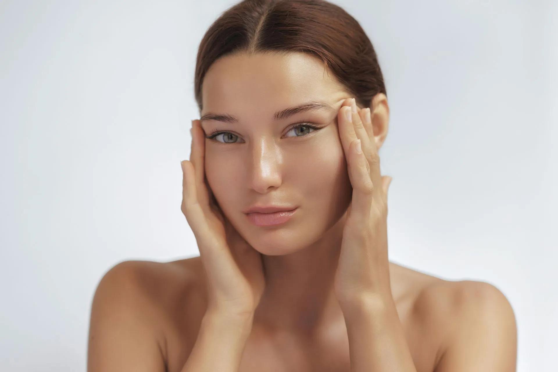A woman is touching here face with both hands