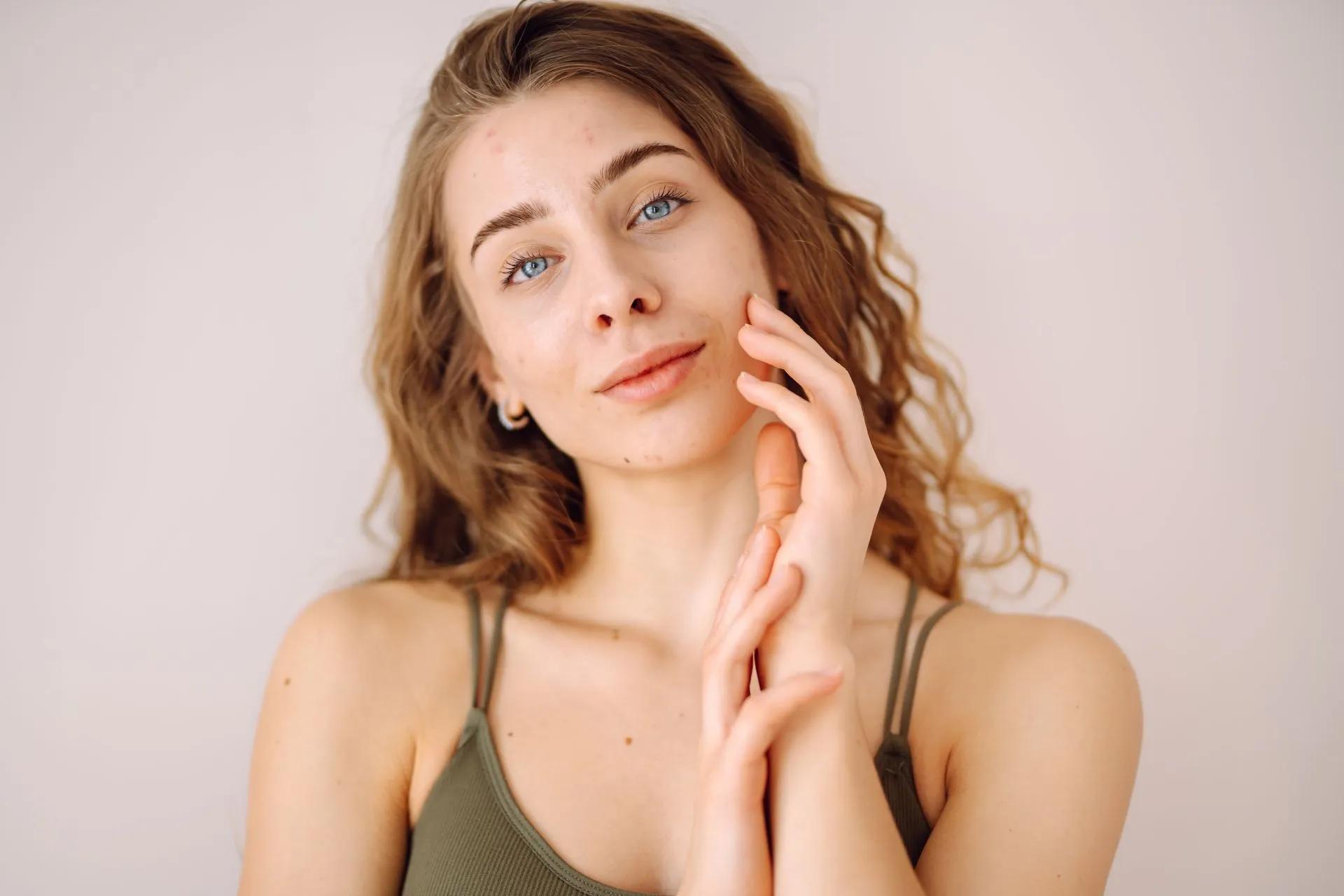 a woman is touching her face and smiling