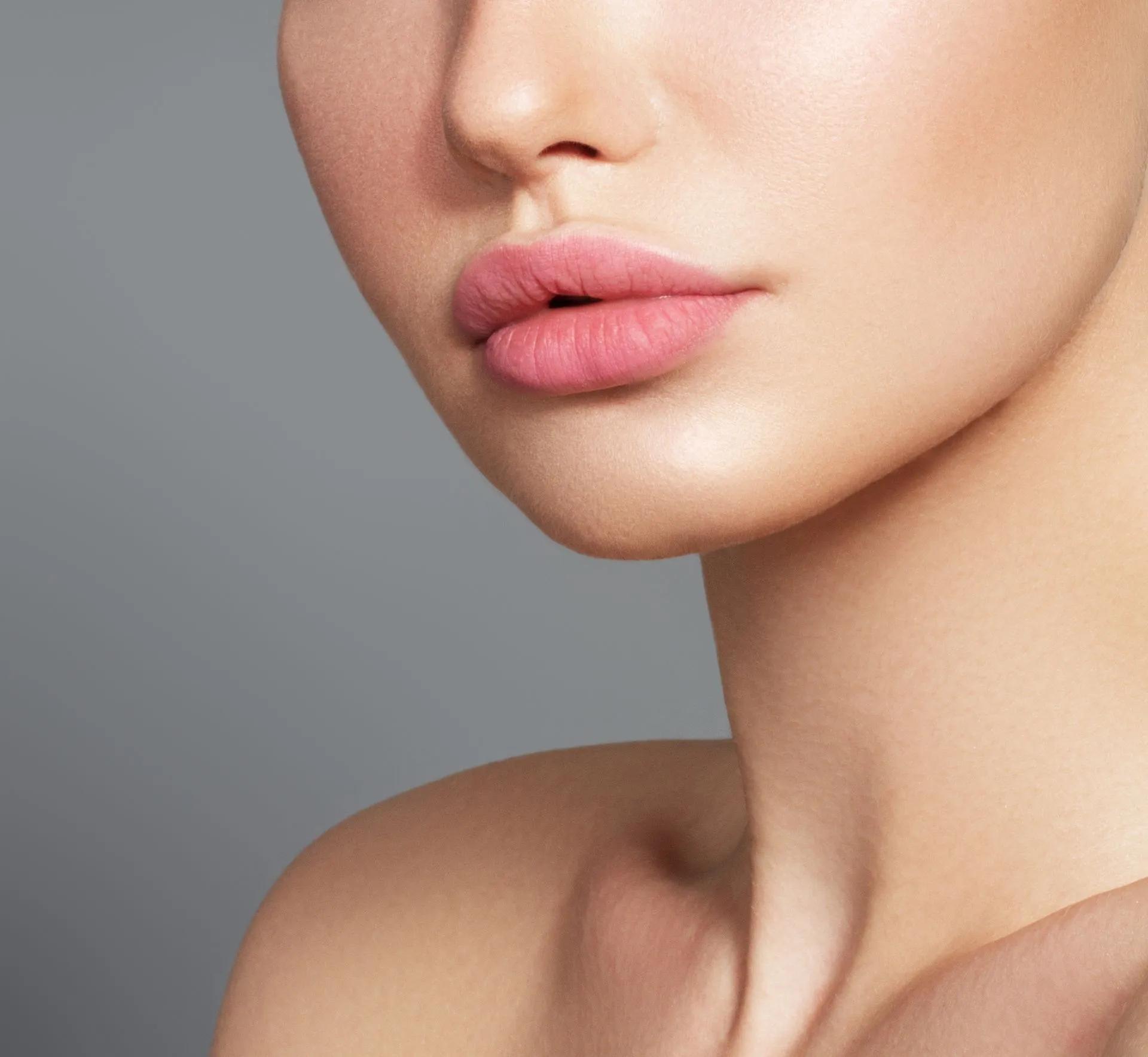 A close up of a woman 's face with pink lips.