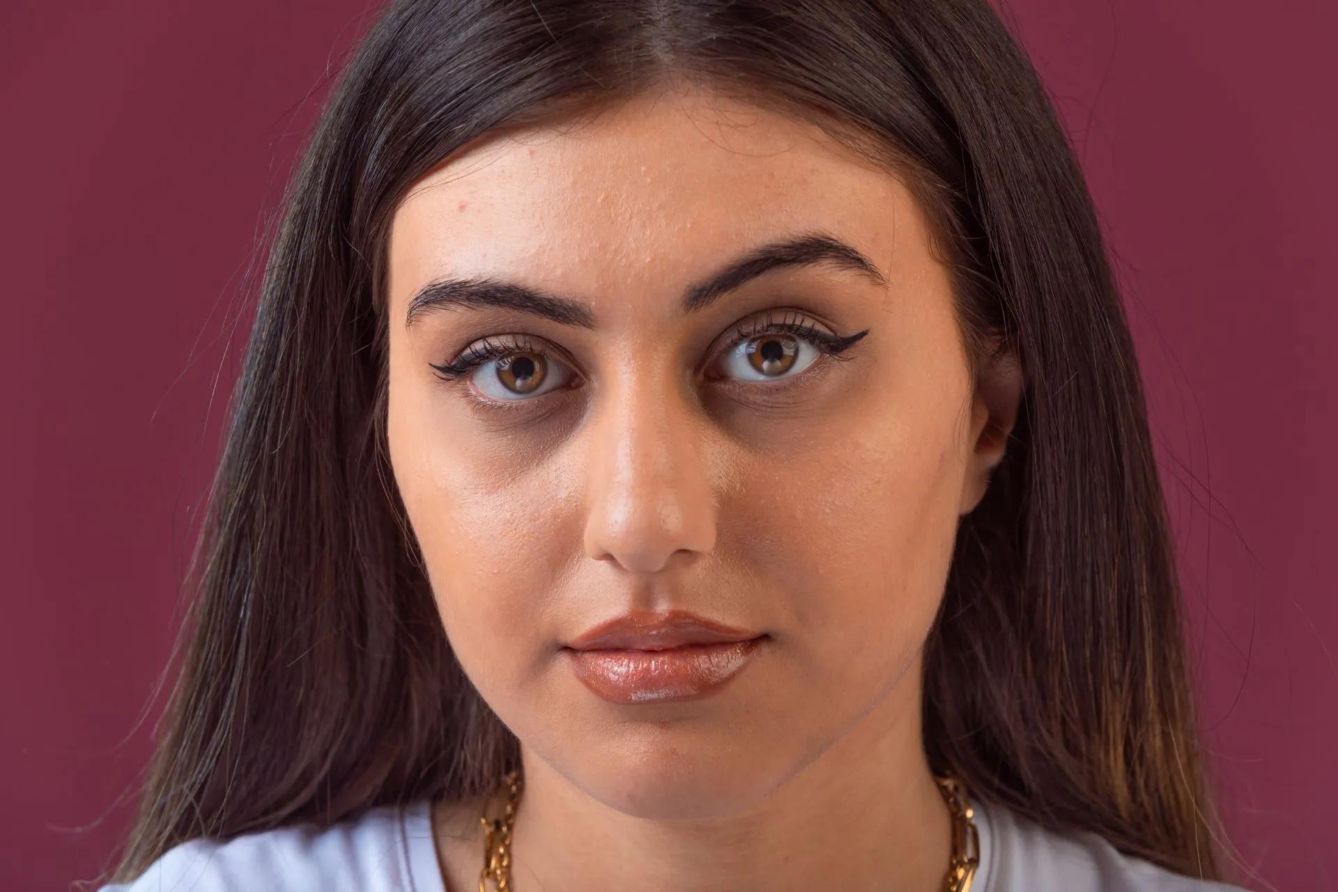 A close up of a woman 's face with a purple background.